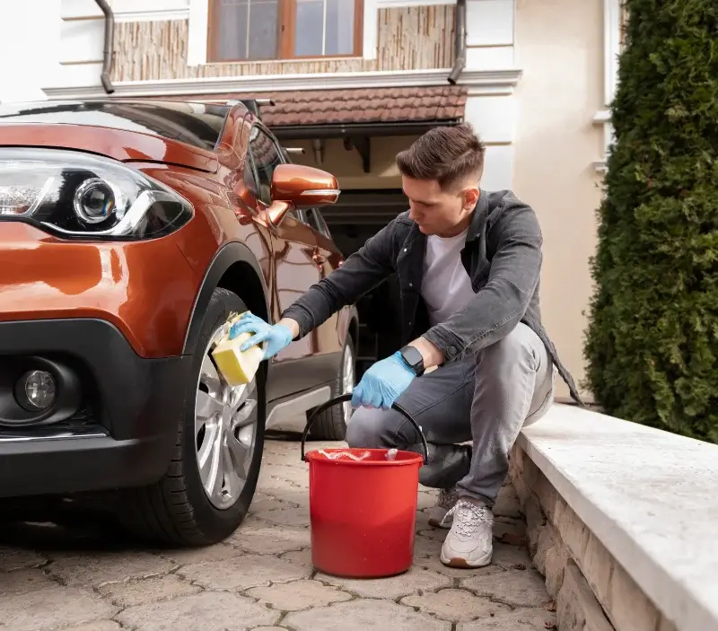 Lavage auto à domicile Dieudonné : professionnel intervenant sur un véhicule